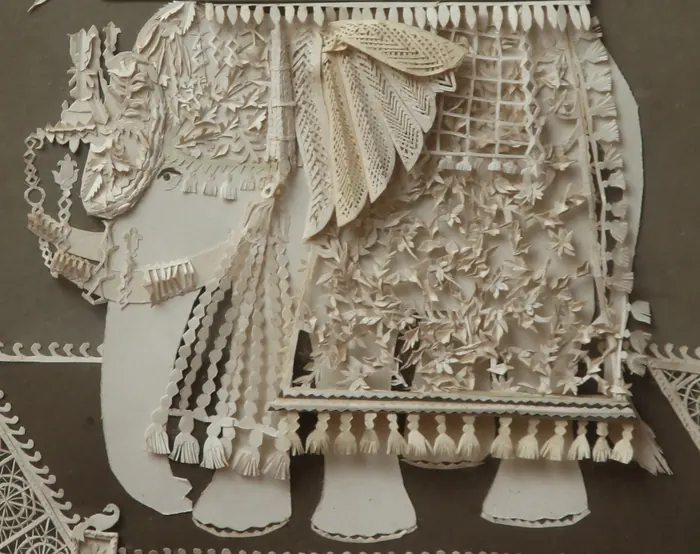 Close-up of a paper elephant's decorated cloth and tassels